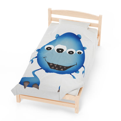 Cute Blue Monster Kids Plush Blanket draped over a child's bed.