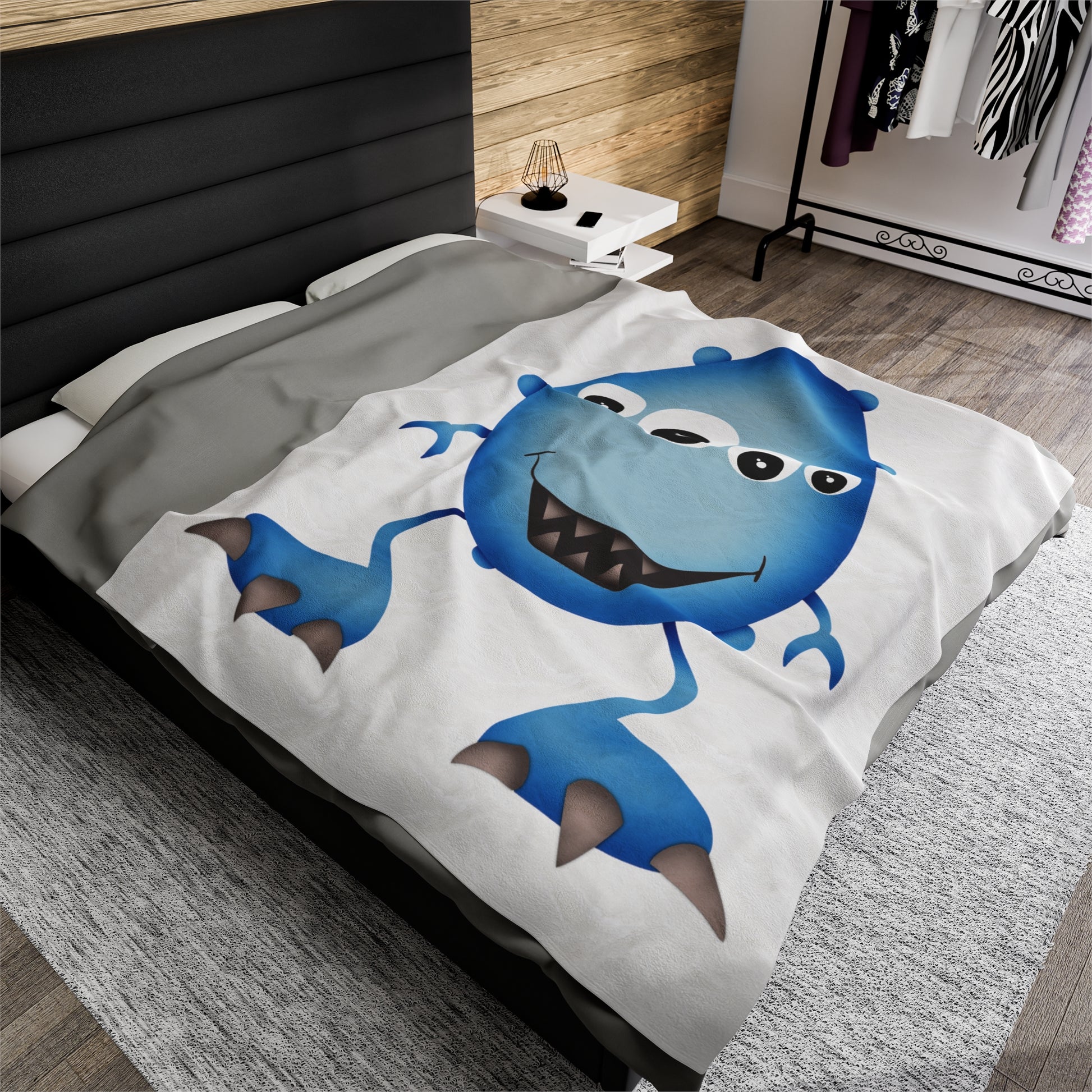 Cute Blue Monster Kids Plush Blanket draped over a child's bed.
