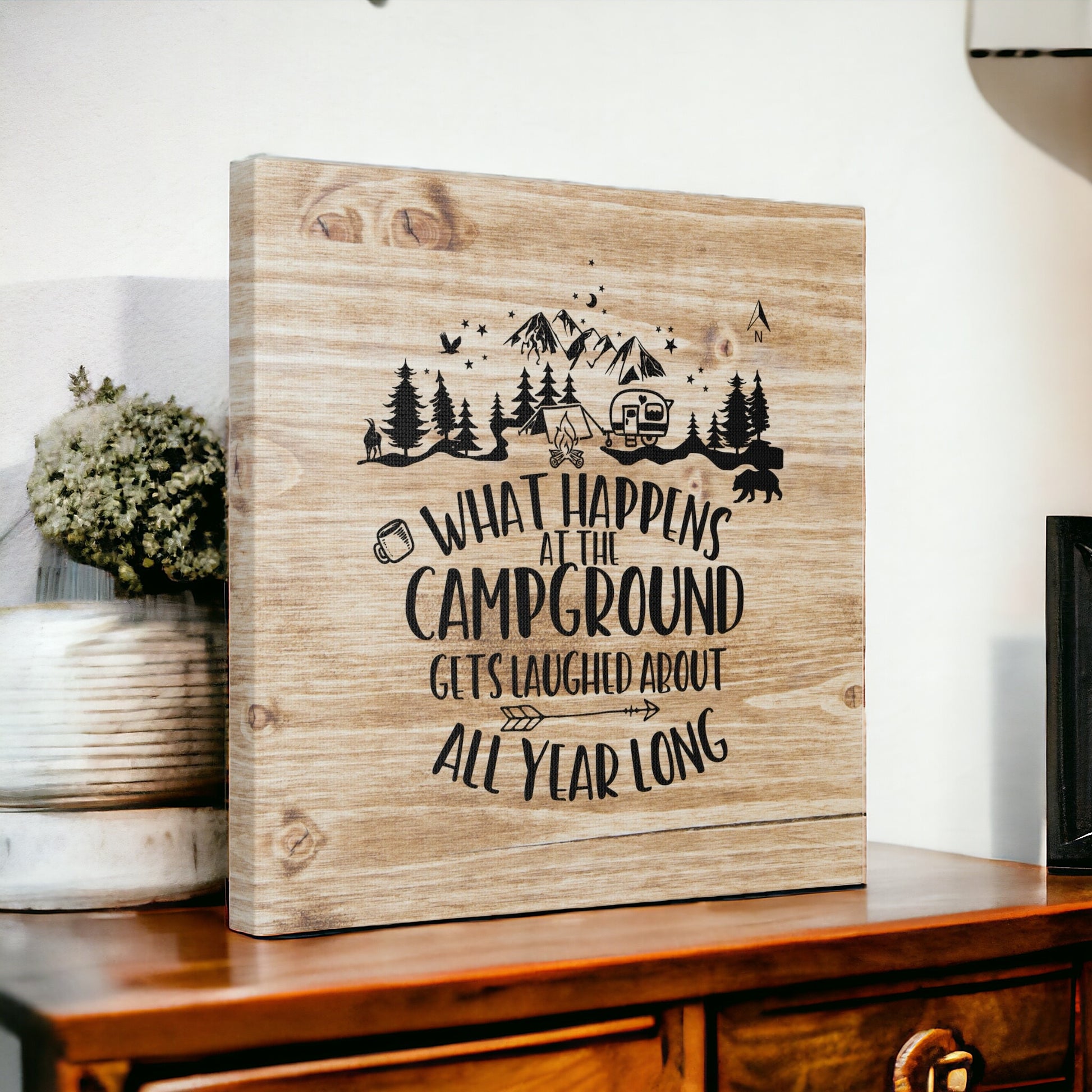 Rustic camping art with wood-look background and humorous quote.
